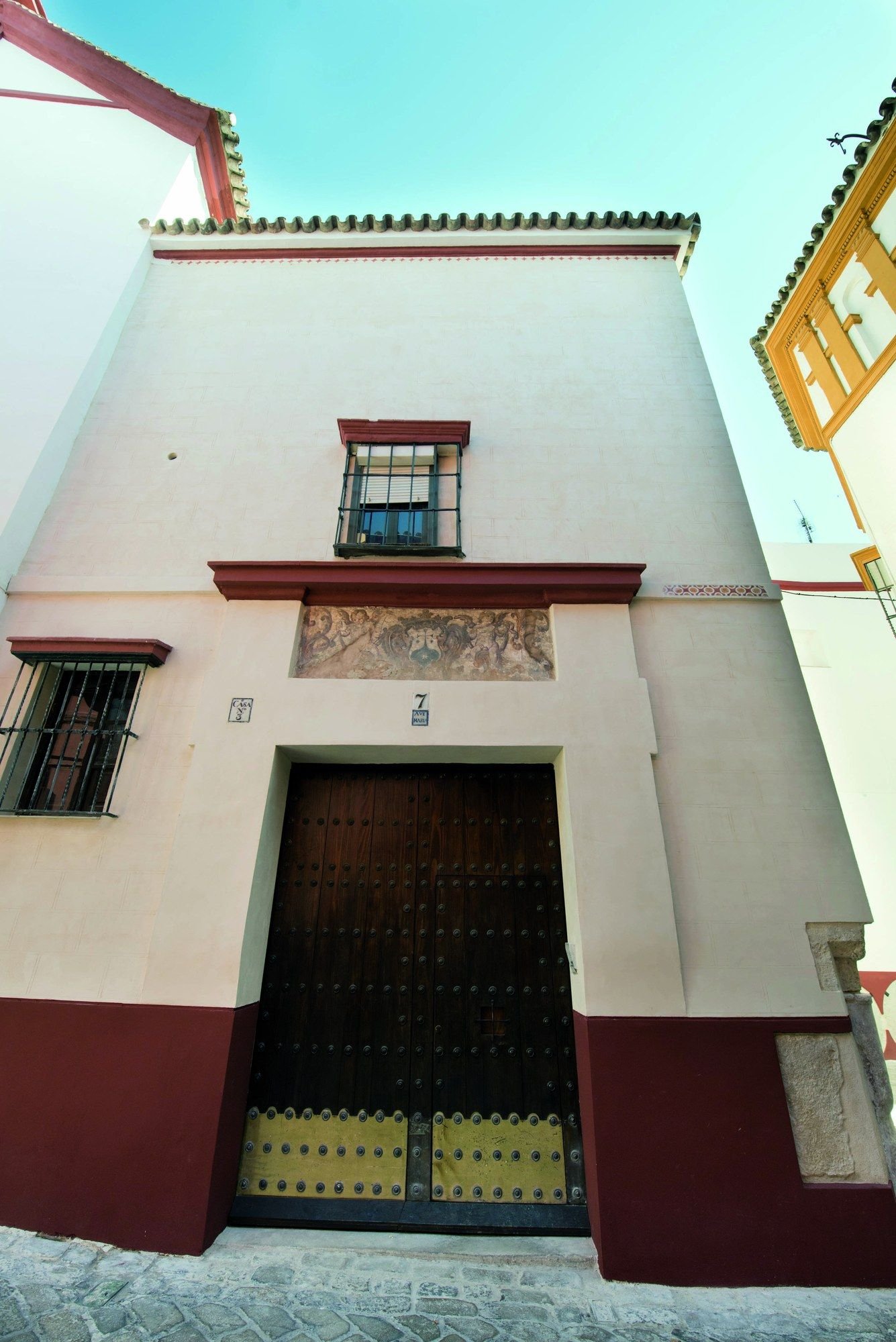 Fachada del convento desde la calle, con el portón de madera y la reja