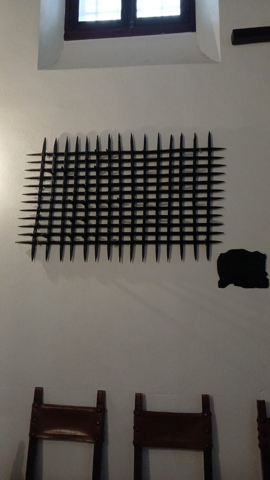 Reja de hierro de púas en una pared blanca